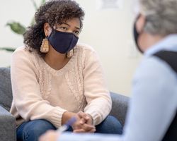 A woman sits in a chair and talks to a therapist.
