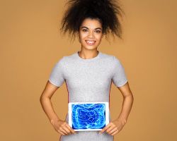 A woman holds a medical scan over her abdomen.