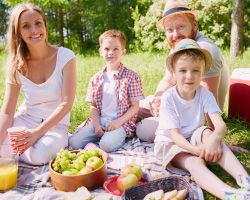 A family enjoying a picnic with their food stored in a cooler